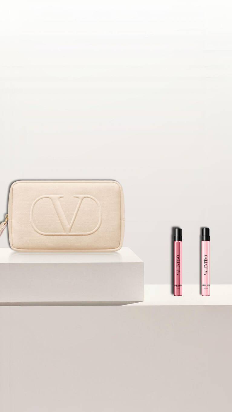 Trousse verte avec logo CV, accompagnee de flacons de parfum et de maquillage sur une surface claire.